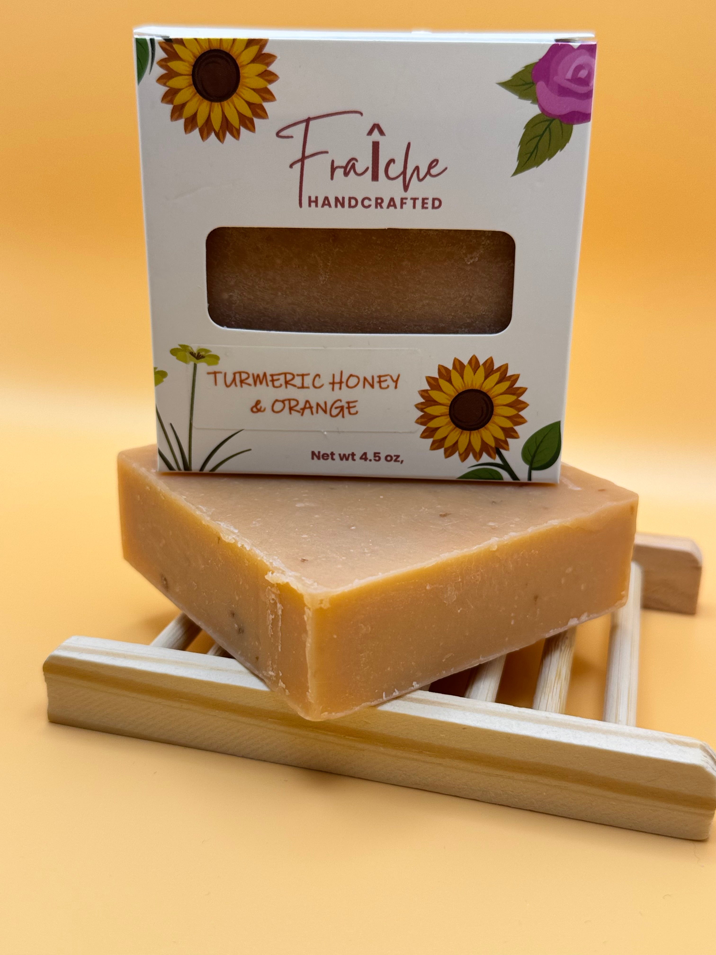 Handcrafted soap bar with packaging featuring sunflowers and a purple flower on a yellow background